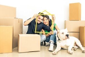 couple and dog with packaging boxes ready to move