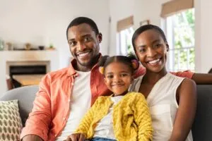 Young African American Couple with small child sitting on a couch