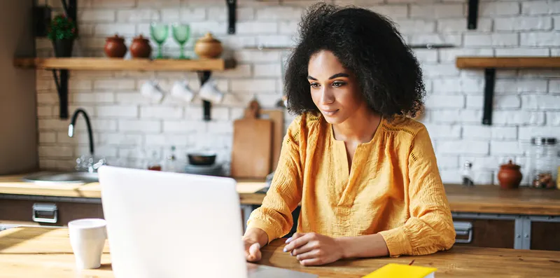 woman in kitchen working on laptop