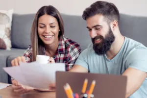 Couple smiles while working on paperwork together