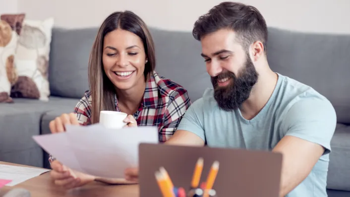 Couple smiles while working on paperwork together