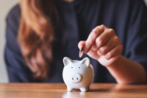 Woman placing money into a piggy bank