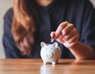 Woman placing money into a piggy bank