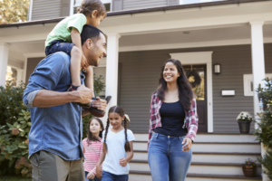 A young family in front of the house.