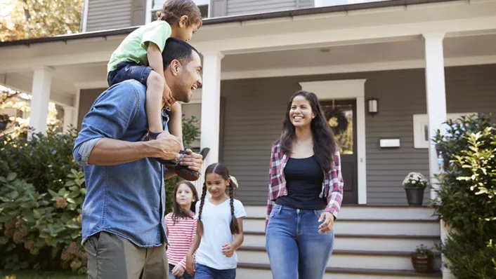 A young family in front of the house.