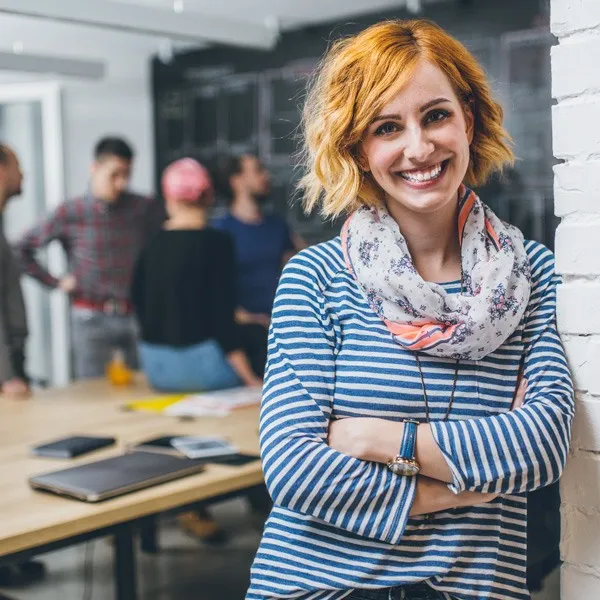 Smiling woman with short red hair wearing a horizontal stripes shirt.