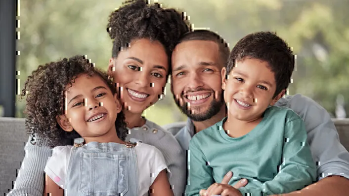 Young African American Couple with Two Young Children on Their Laps Smiling