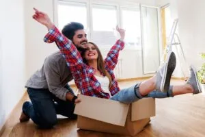 Couple in new home playing with cardboard boxes