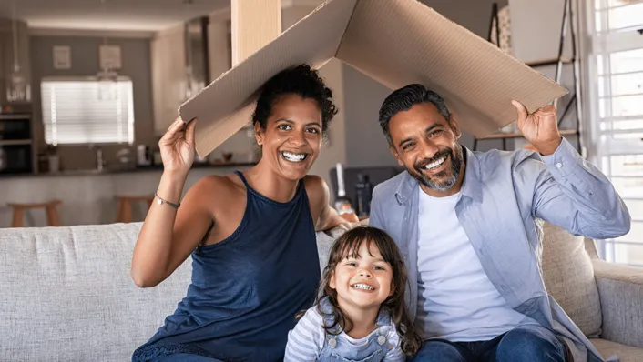 a family of three sitting in their livingroom