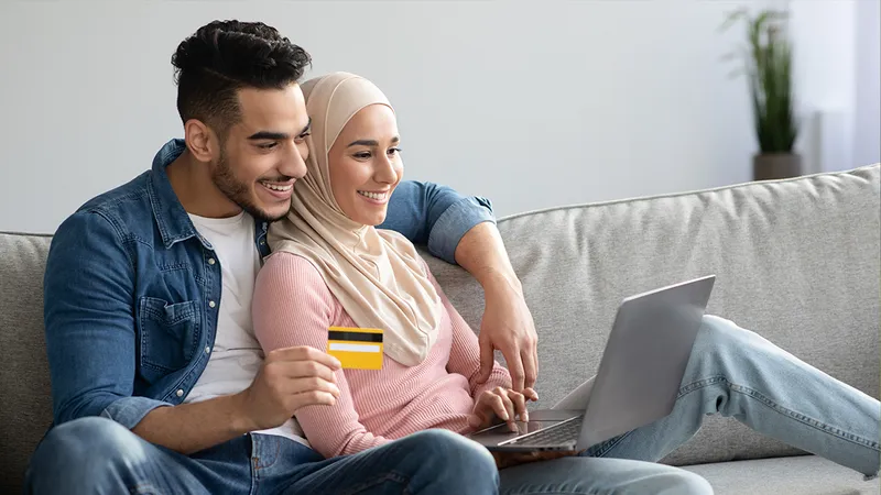 young couple using computer to purchase goods