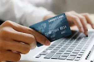 hand holding credit card paying bills on laptop