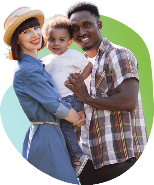 Young couple holds their toddler-aged son while smiling.