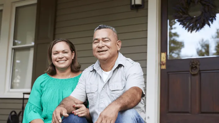 A couple sitting on the porch of their home