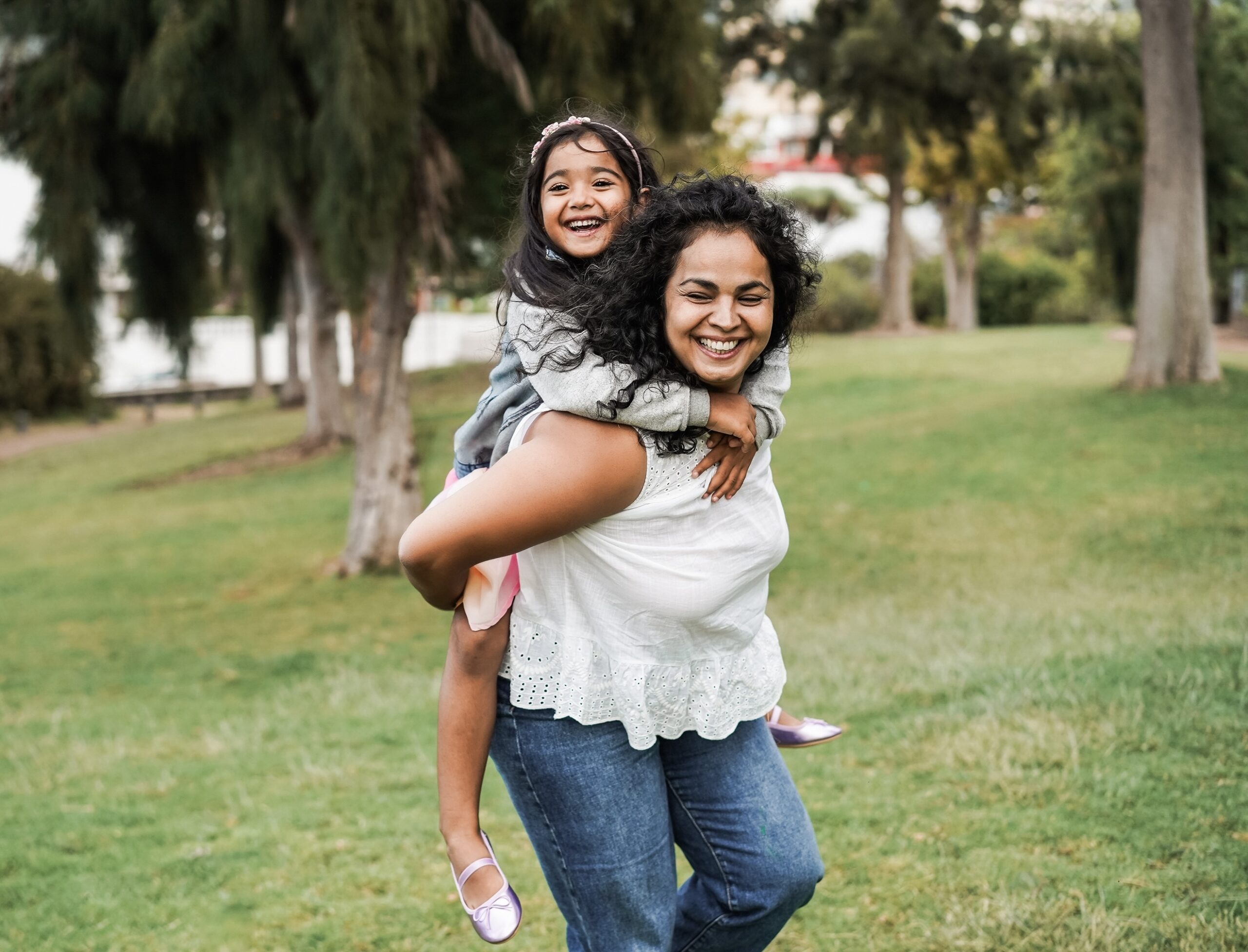 Happy indian mother having fun with her daughter outdoor - Focus on mother face