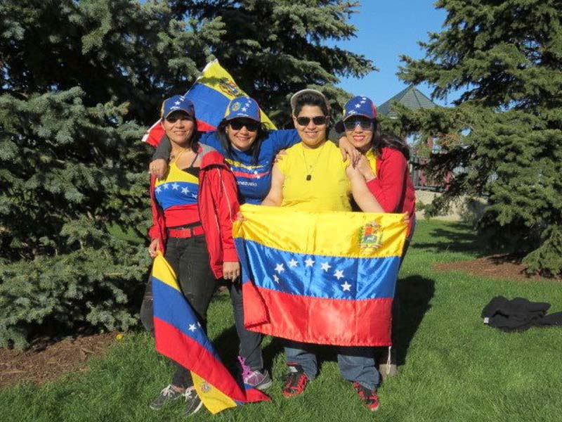 A group of people together holding up a flag