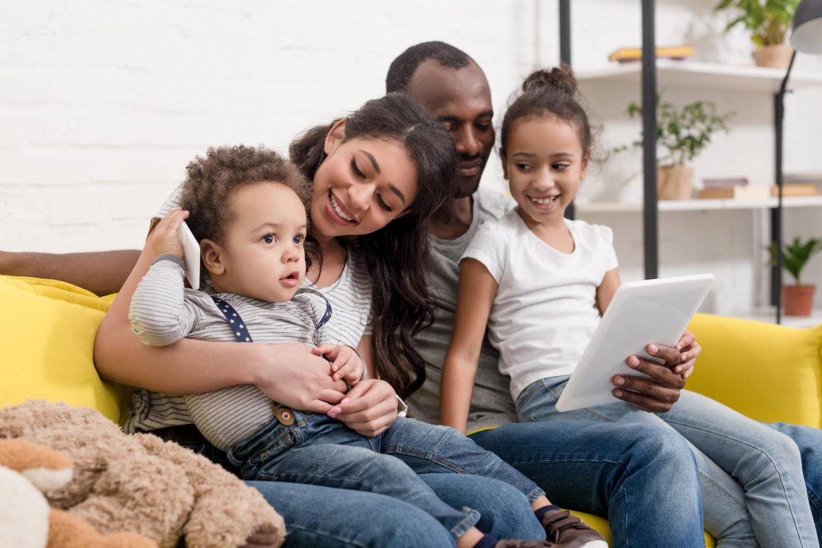 Family sitting on couch using an ipad