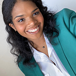 A woman wearing a white blouse and turquoise blazer