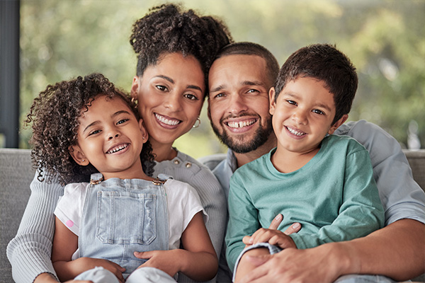 Hispanic family of four smiling at camera