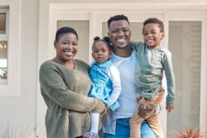 family of four standing infront of their home