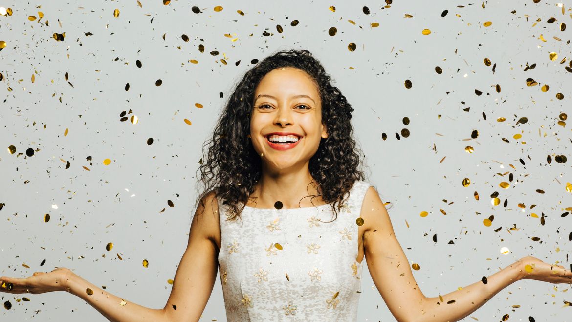 latina woman smiling with confetti falling